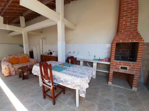 a living room with a table and a fireplace at Maranata Casa com Piscina - 2 minutos de carro até o mar in Peruíbe