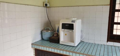 a kitchen counter with a water dispenser on the wall at ABAH HOMESTAY Kuala Terengganu in Kuala Terengganu