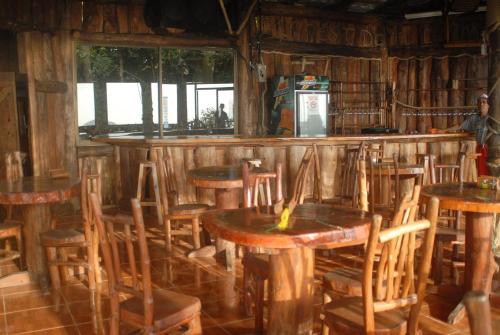 Cabañas Don Camilo Albergue de Montaña في Cabecera de Cañas: وجود بار بطاولات وكراسي خشبية في المطعم