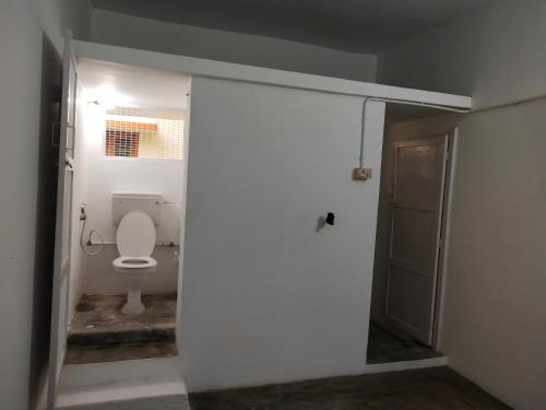 an open door to a bathroom with a toilet at Mayurapriya Inn in Chennai