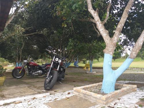 a motorcycle parked next to a tree in a park at Pousada Sao Lourenco in Ubajara