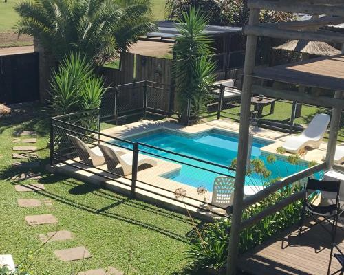 Ein Swimmingpool im Garten mit zwei Stühlen und einem Zaun in der Unterkunft Piedra Mora Loft in Gualeguaychú