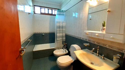 a bathroom with a toilet and a sink and a tub at Amplios Departamentos en Corrientes in Corrientes