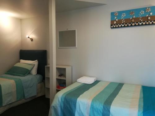 um quarto com 2 camas e um espelho em Coastal Condo em Waitarere