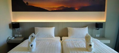 a hotel room with two beds and a painting on the wall at Proud Khaoyai in Pak Chong