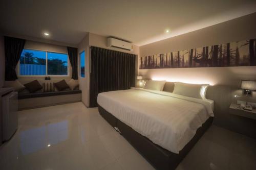 a large bedroom with a large bed and a couch at Proud Khaoyai in Pak Chong