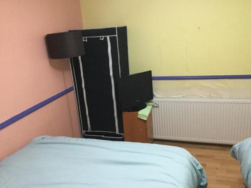 um quarto com uma cama e uma televisão em Holiday / vacation Double Room in Greater manchester em Summerseat