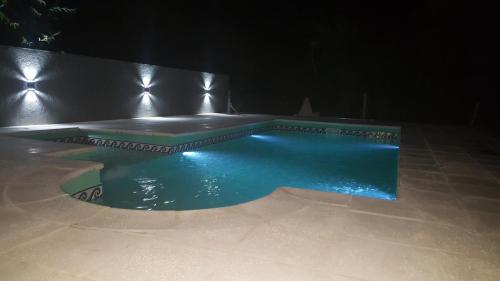 uma piscina à noite com luzes acesas em Apart y Suite Portal del Luz em Mina Clavero