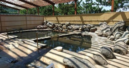 a pool of water with statues of bears in a zoo at たから温泉民宿 Gem Onsen Stay in Sakaimura