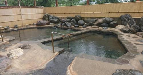 a large pool of water with rocks in a zoo at たから温泉民宿 Gem Onsen Stay in Sakaimura