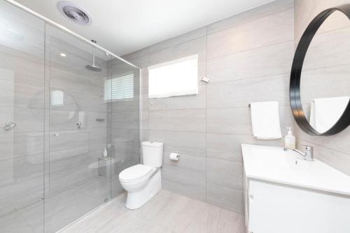 a bathroom with a toilet and a sink and a mirror at Hotel Forster in Forster