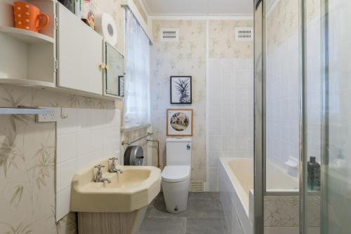 uma casa de banho com um lavatório, um WC e uma banheira em 1 Private Queen room in Carramar 1 Minute Walk To Station em Sydney