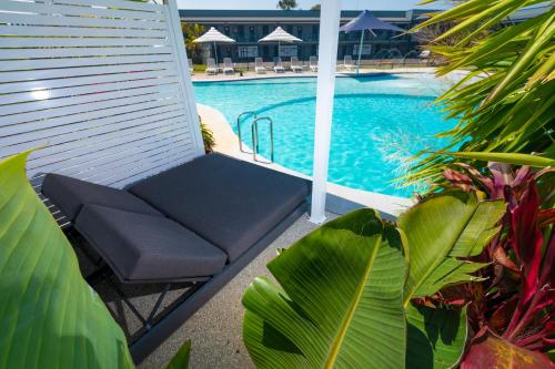 a blue bench sitting next to a swimming pool at Hotel Forster in Forster