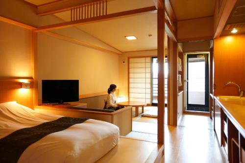 箱根町にある箱根小涌谷温泉水の音の女性がホテルの部屋に座っている