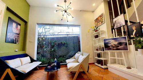 een woonkamer met een bank en een raam bij De Studio HomeStay in Hanoi