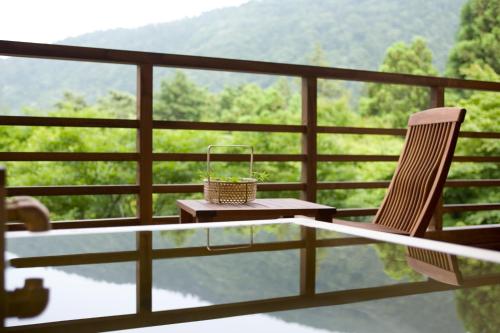 a table and a chair on a balcony with a view at Mizunoto in Hakone