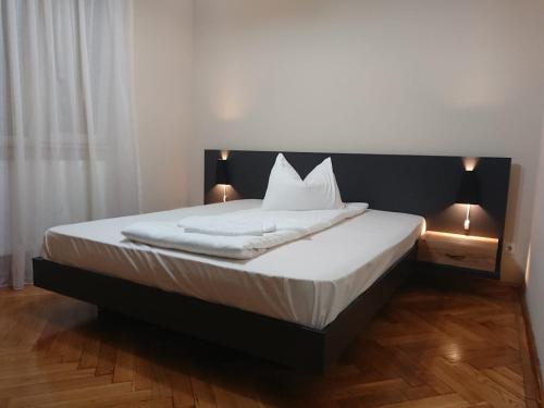 a bedroom with a bed with two lights on it at Apartament Alena in Baile Felix