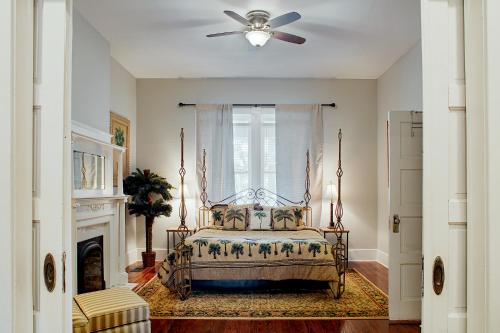Newly Renovated Historic Savannah Townhome! في سافانا: غرفة نوم بسرير ومروحة سقف