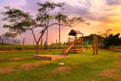 einen Spielplatz mit Rutsche und Baum in der Unterkunft Vista Alegre Natural Resort - Bungalows in Independencia