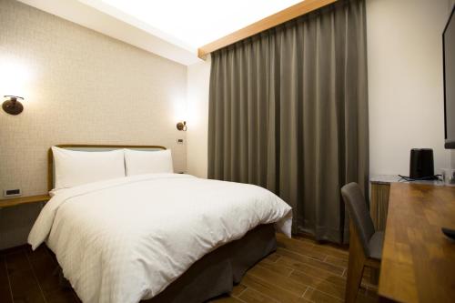 Postel nebo postele na pokoji v ubytování 原鄉商旅 Yuan Hsiang Hotel