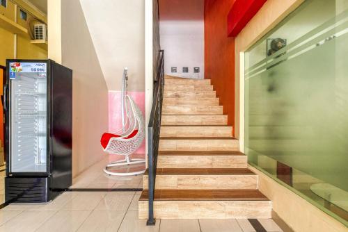 a staircase in a building with a red chair at RedDoorz Syariah @ Kertomenanggal Surabaya in Surabaya