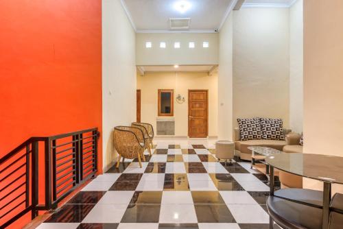a living room with a checkerboard floor at RedDoorz Syariah @ Kertomenanggal Surabaya in Surabaya