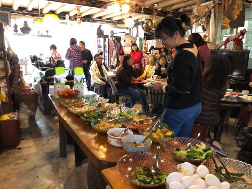 Un groupe de personnes assises à une table avec de la nourriture dans l'établissement Yun Meng Shanlin B&B, à Taian