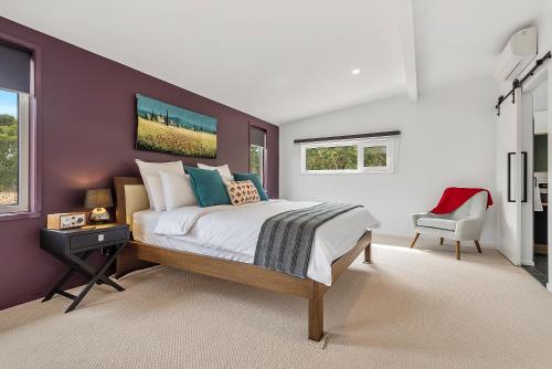 a bedroom with a large bed and a purple wall at Goldie Views in Lance Field