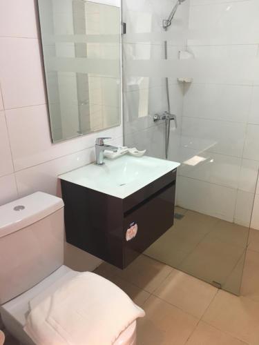 La salle de bains est pourvue d'un lavabo, de toilettes et d'un miroir. dans l'établissement Nakhone Champa Hotel, à Pakse