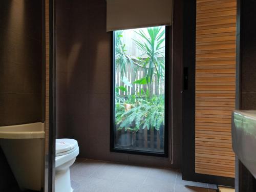 a bathroom with a toilet and a window at Roppongi Motel in Pingtung City