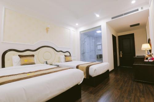 a hotel room with two beds and a window at Vincent Halong Hotel in Ha Long