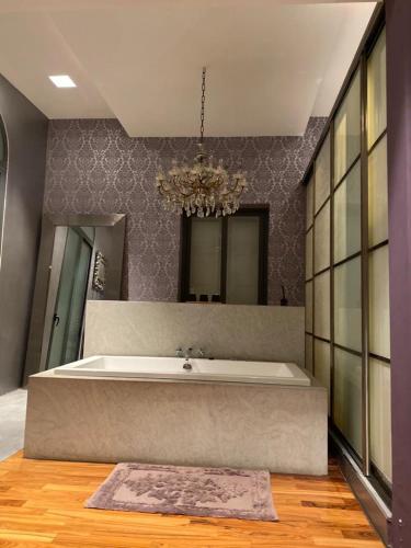 a large bathroom with a large tub and a chandelier at Sliema La Loggia Suites in Sliema