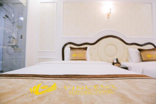 a hotel room with two beds with a king size bed at Vincent Halong Hotel in Ha Long