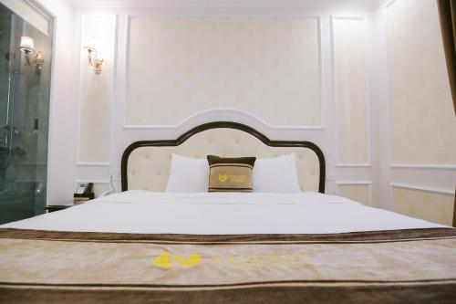 a bed with a bag sitting on top of it at Vincent Halong Hotel in Ha Long