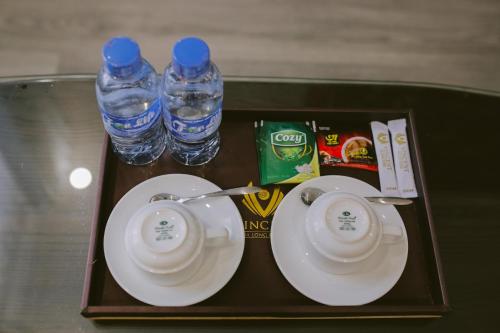 a tray with two plates and two bottles of water at Vincent Halong Hotel in Ha Long