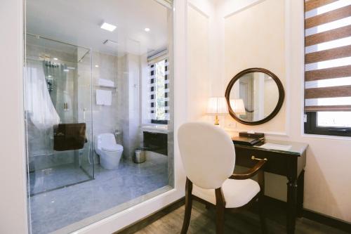 a bathroom with a sink and a toilet and a mirror at Vincent Halong Hotel in Ha Long