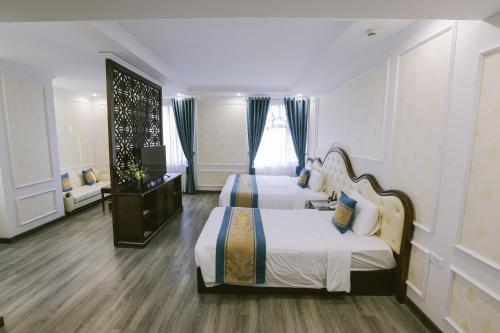 a hotel room with two beds and a window at Vincent Halong Hotel in Ha Long