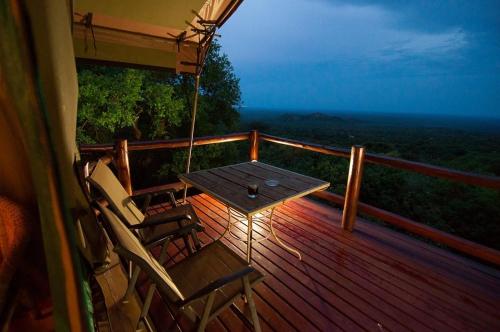 a porch with chairs and a table on a deck at Amafu Forest Lodge in Hoedspruit