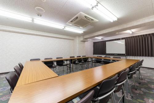 a conference room with a large wooden table and chairs at HOTEL CITY INN WAKAYAMA Wakayama-Ekimae in Wakayama
