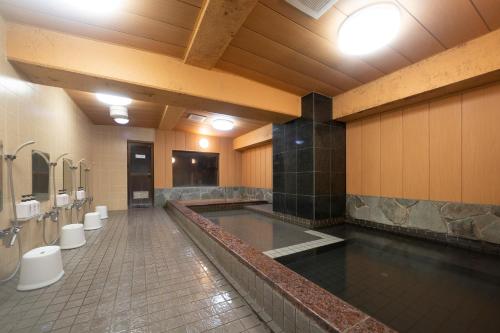 HOTEL CITY INN WAKAYAMA Wakayama-Ekimae في واكاياما: حمام كبير فيه مغاسل ومراحيض