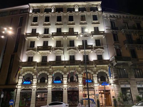 un grande edificio con facciata illuminata di notte di Mokinba Hotels King a Milano
