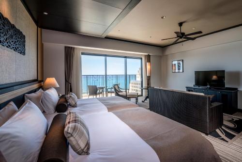 a bedroom with a large bed with a large window at Hotel Monterey Okinawa Spa & Resort in Onna