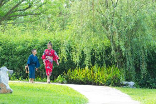 a boy and a girl walking down a path at Zen Next Khao Yai By ZV in Pak Chong