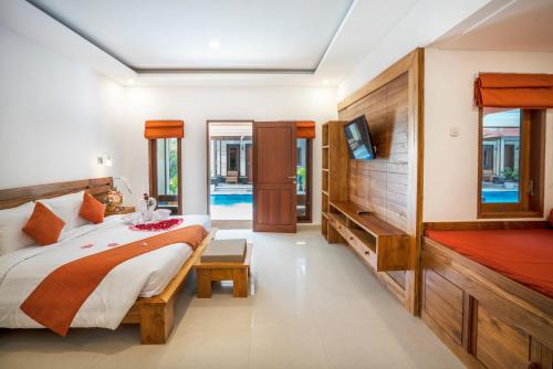 a bedroom with a bed and a flat screen tv at The Salila Beach Resort in Seminyak