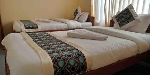un par de camas en una habitación de hotel en Hotel Nana Pokhara, en Pokhara