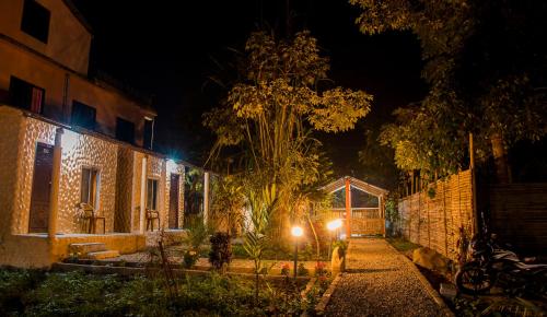 a house with lights on the side of it at night at Hotel Tiger Tops Sauraha in Sauraha