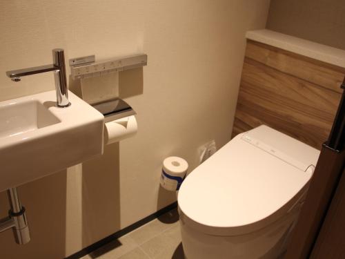 a bathroom with a toilet and a sink at THE BLOSSOM HIBIYA in Tokyo
