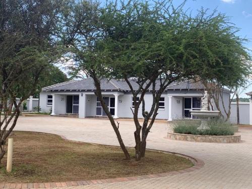 a small tree in front of a white building at La Fiato Luxury Lodge in Dalmada AH