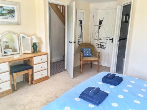 a bedroom with a bed and a desk and a mirror at Daisy in Blackawton