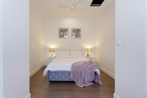 Dormitorio blanco con cama y techo en Emu at White Gum Lodge, en Fremantle